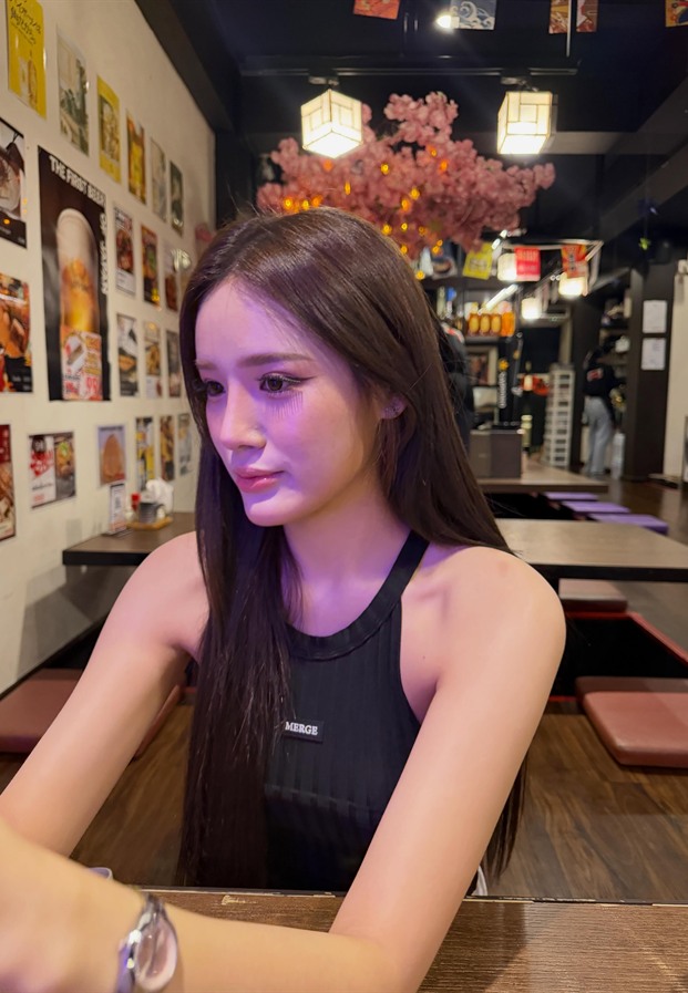 ขนม ในเสื้อกล้ามสีดำนั่งในร้านอาหาร