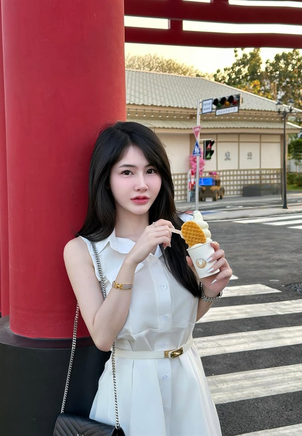 นุ้งนิ้งในเดรสแขนกุดสีขาวถือเครปไอศกรีมหน้าเสาสีแดงสไตล์ญี่ปุ่น