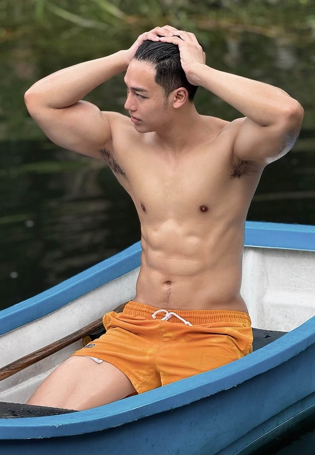 Jiraphong นั่งบนเรือพายในกางเกงสีส้ม