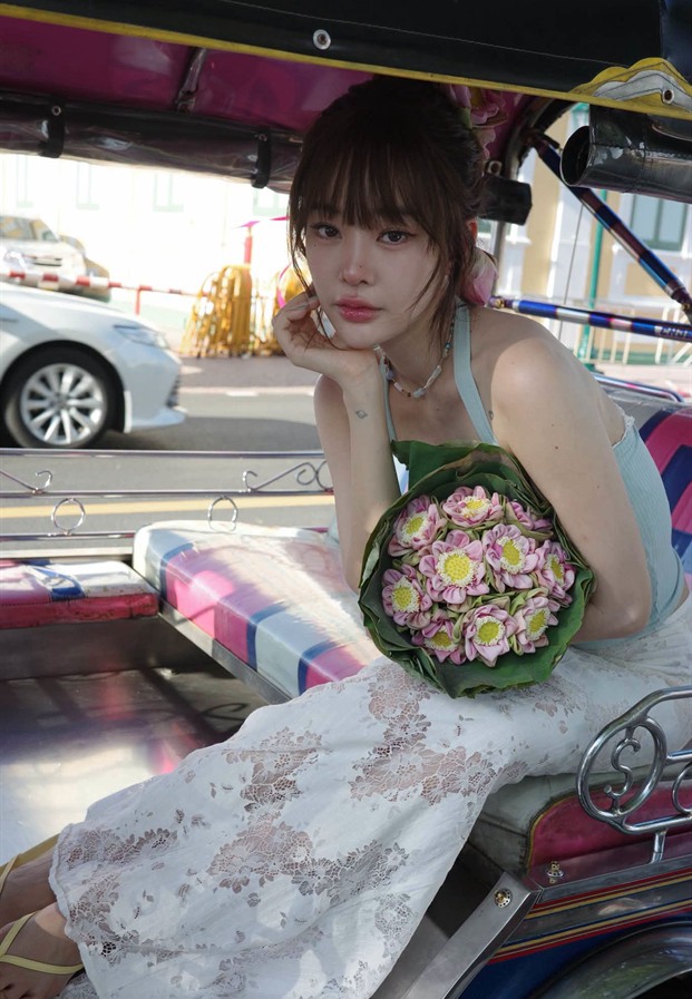 ปุ้มปุ้ยนั่งบนรถตุ๊กตุ๊กถือช่อดอกบัว
